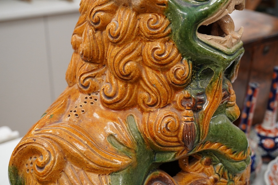 A large pair of Chinese sancai buddhistic lions, 37cm high. Condition - one with small chip near the base
